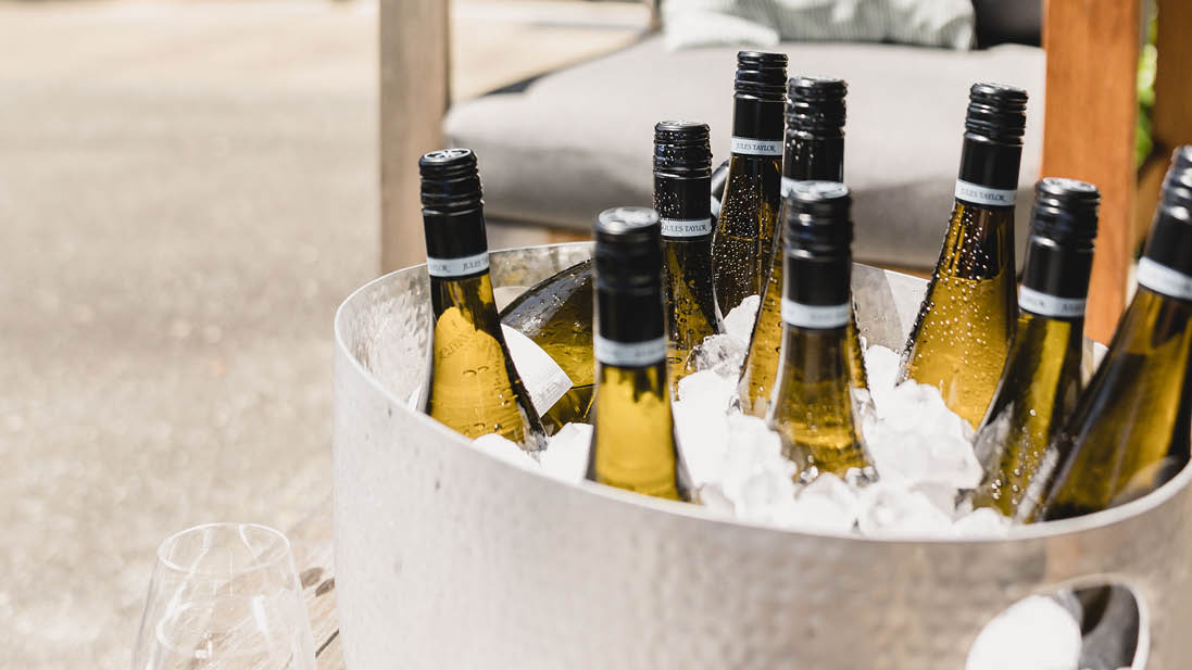Bottles of white wine in a bucket of ice on a patio
